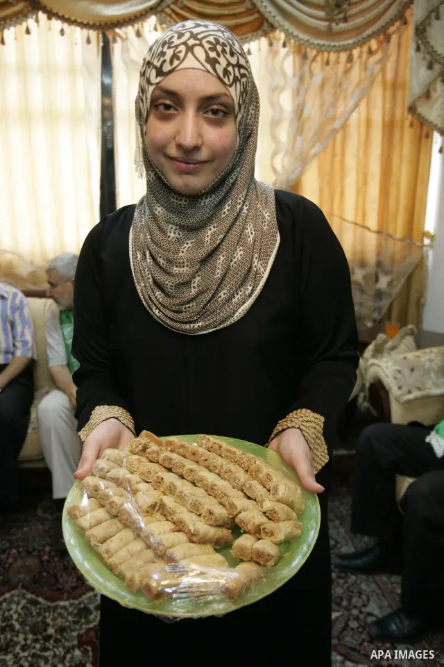 Hadeel Jamal Jaber, a Palestinian secondary school student and the winner of the fourth level in Palestine distributes sweets to her family in Gaza city on July 24, 2011.. Photo by Abed Rahim Khatib