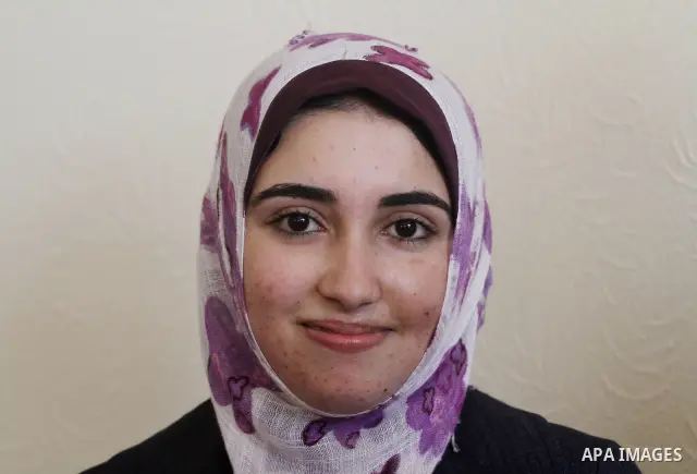 A Palestinian secondary school student and the first in section literary, Asmaa` Al-Sahhar celebrates with her family after hear her result in Gaza city on July 24,2011. The Ministry of Education in Gaza Strip and the We...