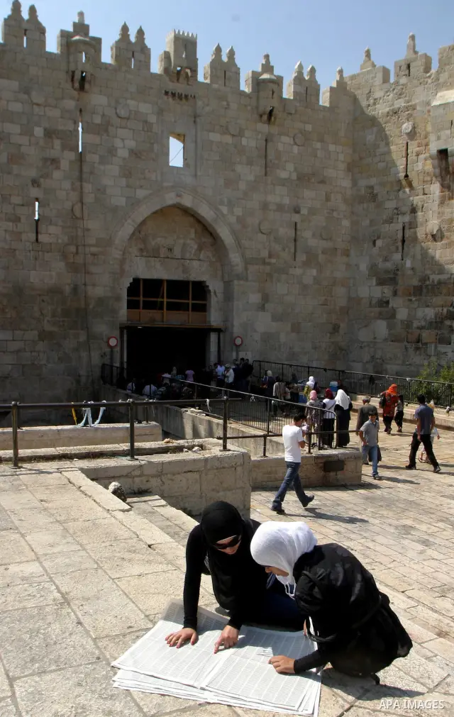 Palestinian students read a local newspaper as they look for their results of final high school exams, known as "Tawjihi" in Jerusalem's old city on July 24,2011.. Photo by Mahfouz Abu Turk