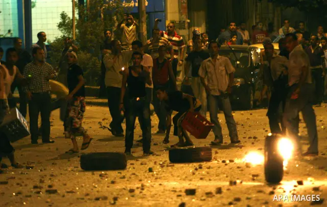 Demonstrators throw rocks during clashes with loyalists of the ruling military council in Abbasiya district, where the army blocked the road leading to the defence ministry, the headquarters of the Supreme Council of the...