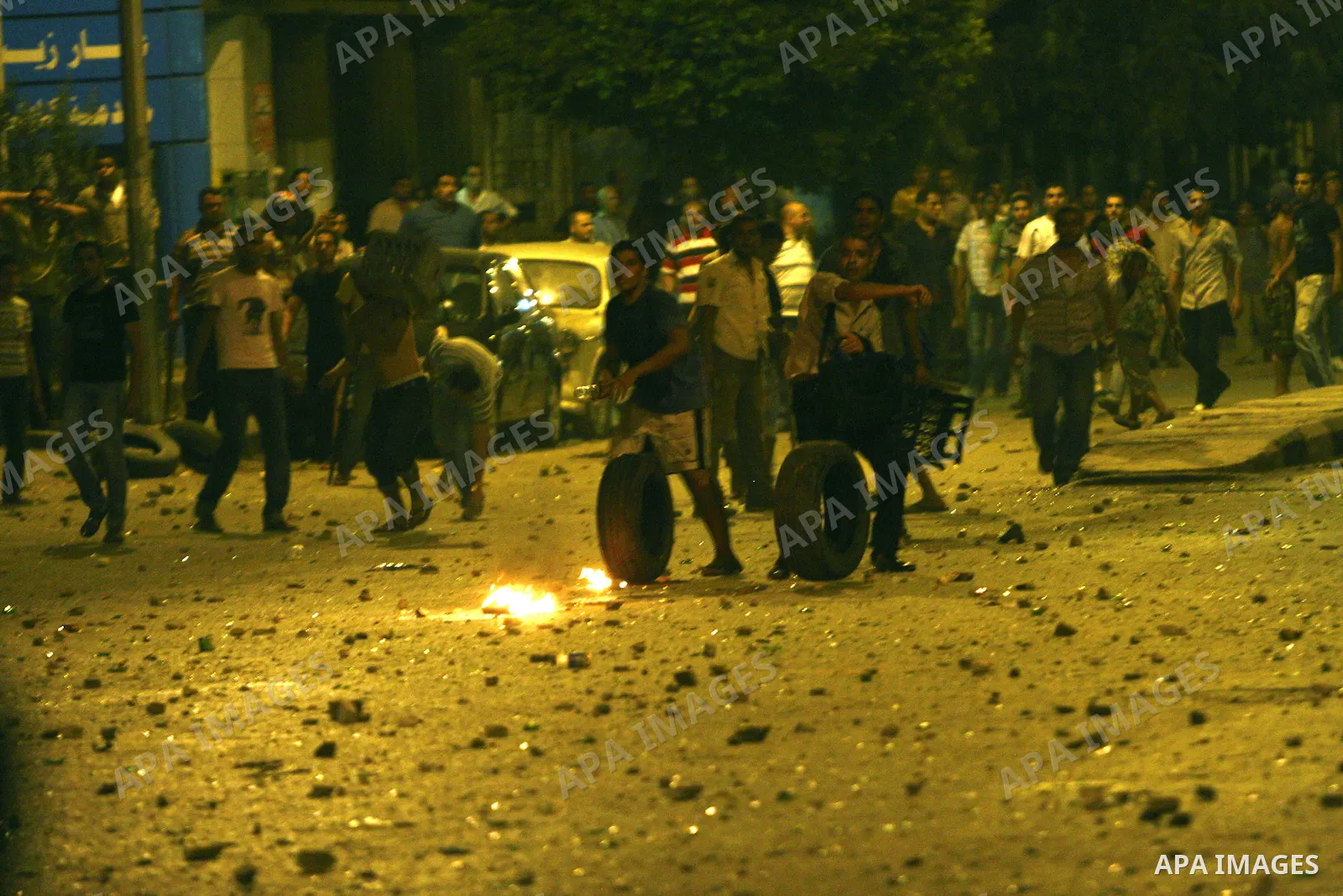 Demonstrators throw rocks during clashes with loyalists of the ruling military council in Abbasiya district, where the army blocked the road leading to the defence ministry, the headquarters of the Supreme Council of the...