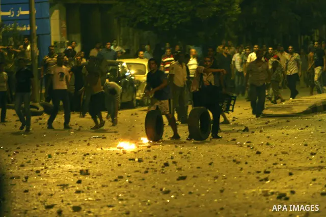 Demonstrators throw rocks during clashes with loyalists of the ruling military council in Abbasiya district, where the army blocked the road leading to the defence ministry, the headquarters of the Supreme Council of the...
