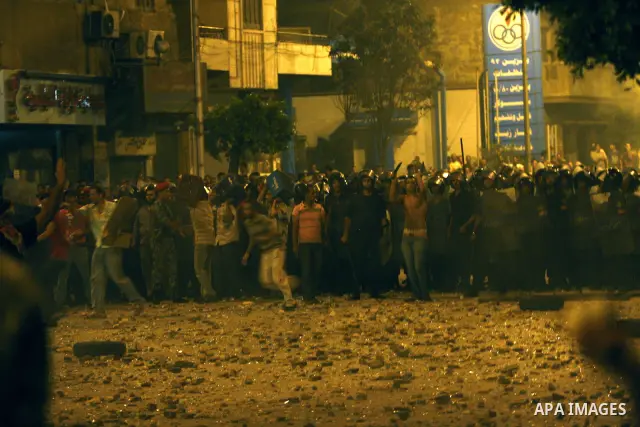 Demonstrators throw rocks during clashes with loyalists of the ruling military council in Abbasiya district, where the army blocked the road leading to the defence ministry, the headquarters of the Supreme Council of the...