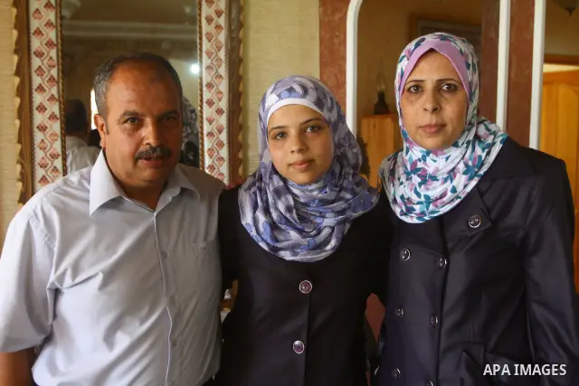 Maram Mostafa Salah, a Palestinian student in secondary school and winning first place in the Gaza Strip, celebrates with her family after she received their results of final high school exams in Gaza city on July 24, 20...