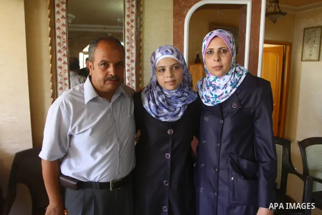 Maram Mostafa Salah, a Palestinian student in secondary school and winning first place in the Gaza Strip, celebrates with her family after she received their results of final high school exams in Gaza city on July 24, 20...