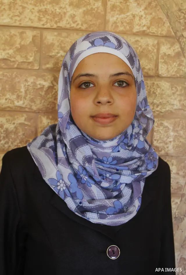 Maram Mostafa Salah, a Palestinian student in secondary school and winning first place in the Gaza Strip, celebrates with her family after she received their results of final high school exams in Gaza city on July 24, 20...