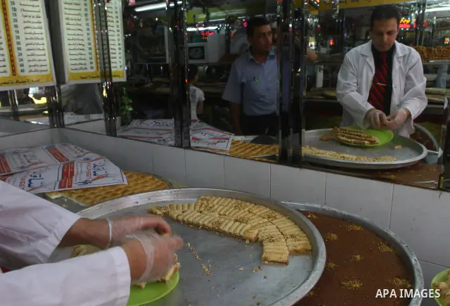 A Palestinian vendor distributes sweets after the results of high school exams, or "Tawjihe", in Gaza city on July 24, 2011. The Ministry of Education in Gaza Strip and the West Bank announced the results together. Photo...