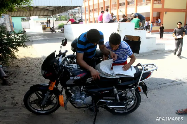 Palestinian secondary school students read a local newspaper to find their results in Gaza city on July 24,2011. The Ministry of Education in Gaza Strip and the West Bank announced the results together. Photo by Ashraf a...