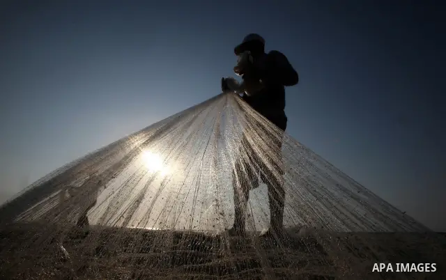 A Palestinian fisherman prepares his nets for fishing at Shatie refugee camp beach, western Gaza city, 24 July 2011. The UN Relief and Works Agency (UNRWA) will reduce some of its services for Palestinian refugees due to...