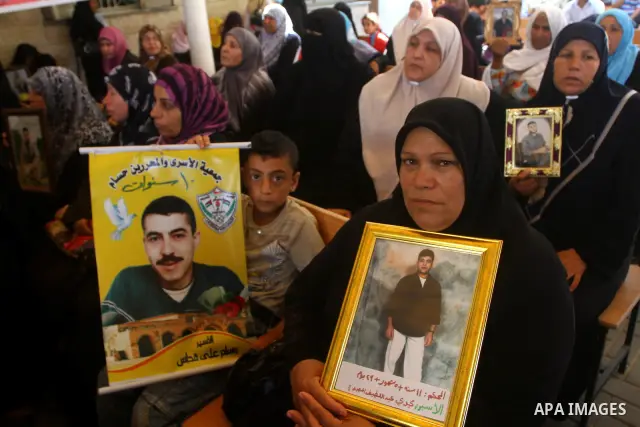 Palestinians women hold pictures of their prisoned relatives in Israeli jails as they gather in a weekly activity calling for their liberty at the Red Cross headquarters in Gaza City on July 25, 2011. About 7000 prisoner...