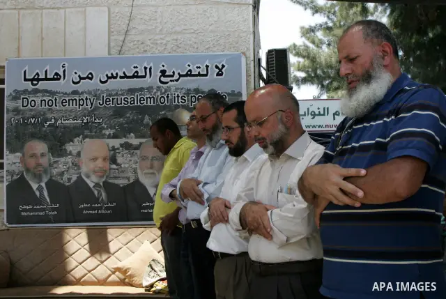 Palestinian Hamas legislators Ahmed Atun, Mohammed Totah and Khaled Abu Arafa perform pray during a protest at the Red Cross compound in east Jerusalem on July 26, 2011. The Hamas MPs live inside the compound for the pas...