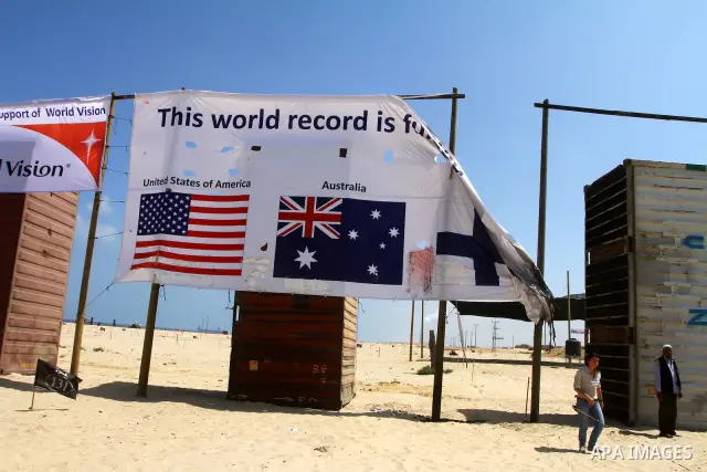A UN employee inspects burnt billboard at a summer camp in northern Gaza City, on July 28, 2011. Unknown individuals attacked on Thursday a summer camp for schoolchildren sponsored by United Nations Relief and Work Agenc...