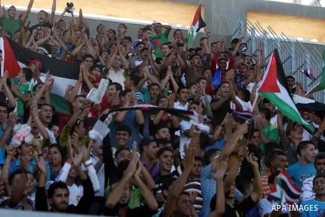 Fans wave Palestinian flags as they cheer during the 2014 FIFA World Cup qualification soccer match between Thailand and the Palestinian Territories at A-Ram stadium near Jerusalem July 28, 2011 Photo by Issam Rimawi