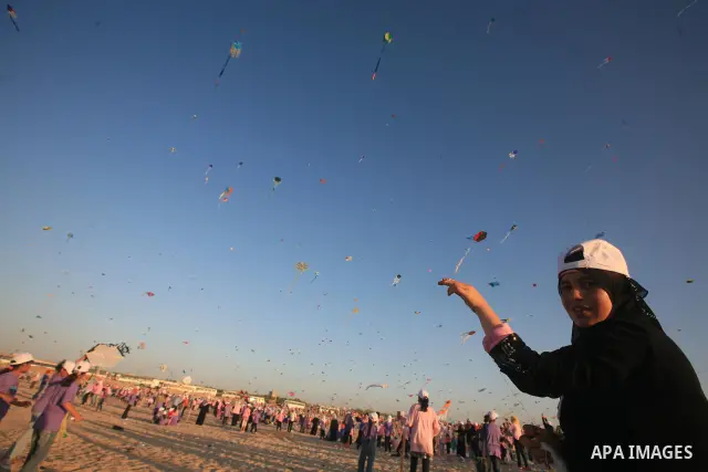 Palestinian children fly kites during an event organized by the United Nations Relief and Works Agency (UNRWA), as they seek to achieve a world record for flying kites, in the northern Gaza Strip, Thursday, July 28, 2011...