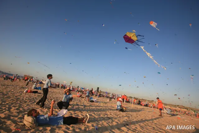 Palestinian children fly kites during an event organized by the United Nations Relief and Works Agency (UNRWA), as they seek to achieve a world record for flying kites, in the northern Gaza Strip, Thursday, July 28, 2011...