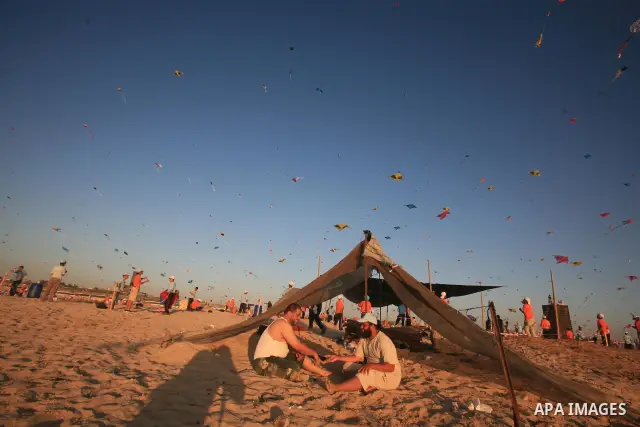 Palestinian children fly kites during an event organized by the United Nations Relief and Works Agency (UNRWA), as they seek to achieve a world record for flying kites, in the northern Gaza Strip, Thursday, July 28, 2011...