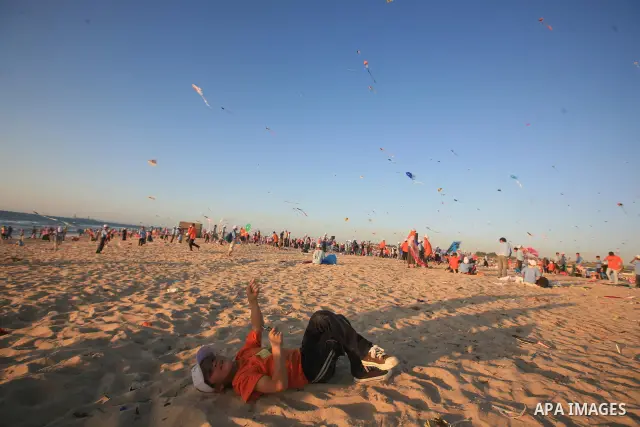Palestinian children fly kites during an event organized by the United Nations Relief and Works Agency (UNRWA), as they seek to achieve a world record for flying kites, in the northern Gaza Strip, Thursday, July 28, 2011...