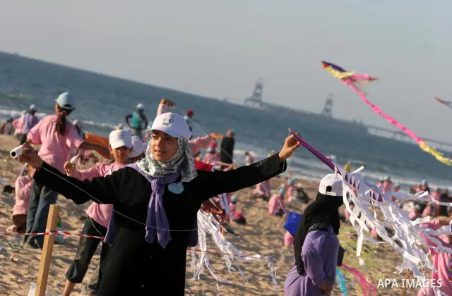 Palestinian children fly kites during an event organized by the United Nations Relief and Works Agency (UNRWA), as they seek to achieve a world record for flying kites, in the northern Gaza Strip, Thursday, July 28, 2011...
