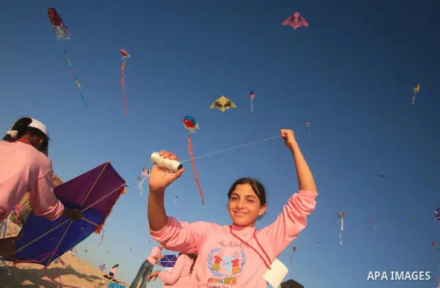 Palestinian children fly kites during an event organized by the United Nations Relief and Works Agency (UNRWA), as they seek to achieve a world record for flying kites, in the northern Gaza Strip, Thursday, July 28, 2011...