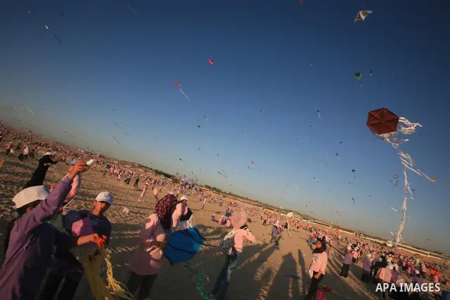 Palestinian children fly kites during an event organized by the United Nations Relief and Works Agency (UNRWA), as they seek to achieve a world record for flying kites, in the northern Gaza Strip, Thursday, July 28, 2011...