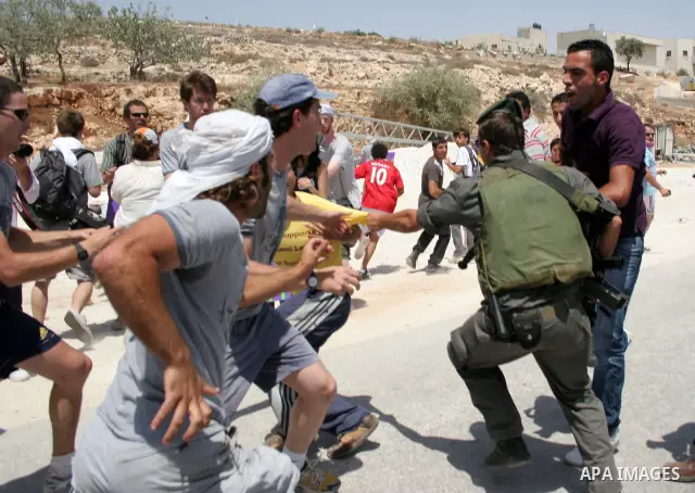 Protesters argue with an Israeli soldiers during a demonstration against Israel's controversial separation barrier in the West Bank village of Maasarah, near the biblical town of Bethlehem on 29 July 2011. Israel says th...
