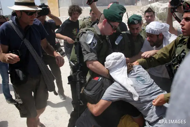 Protesters argue with an Israeli soldiers during a demonstration against Israel's controversial separation barrier in the West Bank village of Maasarah, near the biblical town of Bethlehem on 29 July 2011. Israel says th...