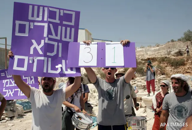 Protesters argue with an Israeli soldiers during a demonstration against Israel's controversial separation barrier in the West Bank village of Maasarah, near the biblical town of Bethlehem on 29 July 2011. Israel says th...
