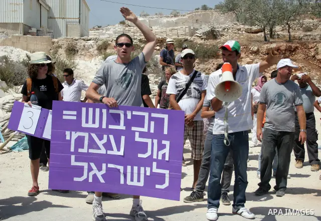 Protesters argue with an Israeli soldiers during a demonstration against Israel's controversial separation barrier in the West Bank village of Maasarah, near the biblical town of Bethlehem on 29 July 2011. Israel says th...