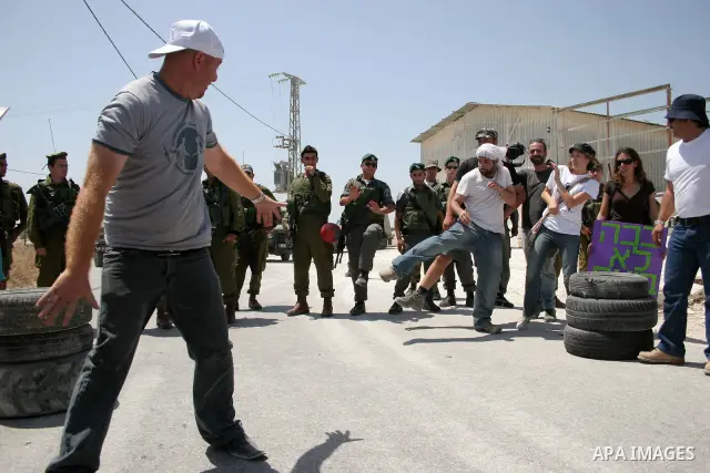 Protesters argue with an Israeli soldiers during a demonstration against Israel's controversial separation barrier in the West Bank village of Maasarah, near the biblical town of Bethlehem on 29 July 2011. Israel says th...