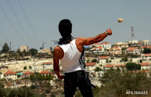 Palestinian youths hurl stones at Israeli security forces, during a protest about Palestinian access to lands in the area, in the village of Kufr Qaddum near the Israeli settlement of Kdumim, in the northern West Bank Fr...