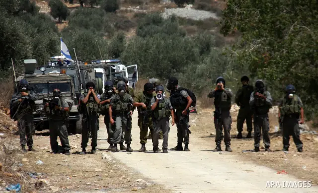 Israeli soldiers take positions during a protest about Palestinian access to lands in the area, in the village of Kufr Qaddum near the Israeli settlement of Kdumim, in the northern West Bank Friday, July 29, 2011. Photo...