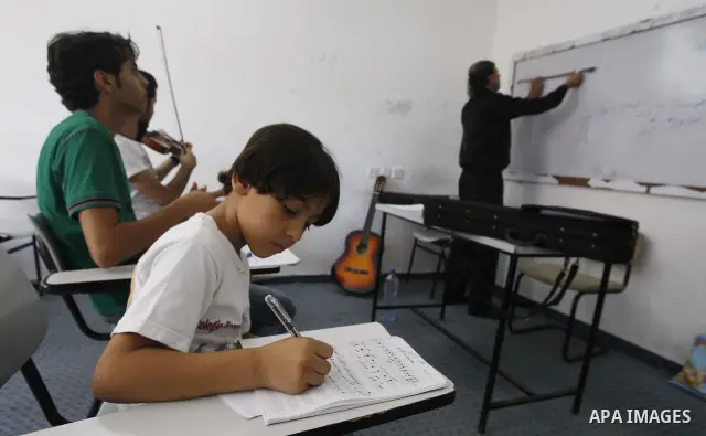 A Palestinian Music teacher during teaching students the lessons on musical instruments at the Gaza College in the Department of Music in Gaza city on July 30, 2011. Photo by Mahmud Nassar