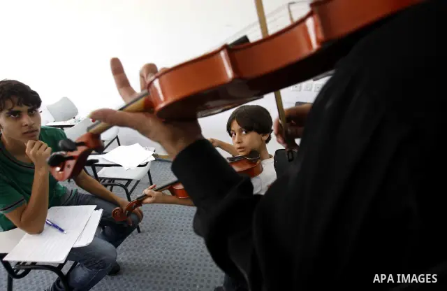 A Palestinian Music teacher during teaching students on on musical instruments at the Gaza College in the Department of Music in Gaza city on July 30, 2011. Photo by Mahmud Nassar
