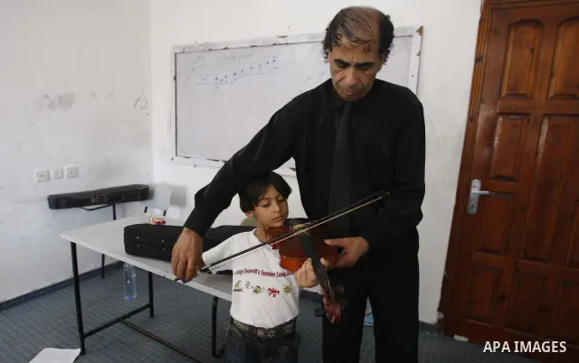 A Palestinian Music teacher during teaching students on on musical instruments at the Gaza College in the Department of Music in Gaza city on July 30, 2011. Photo by Mahmud Nassar