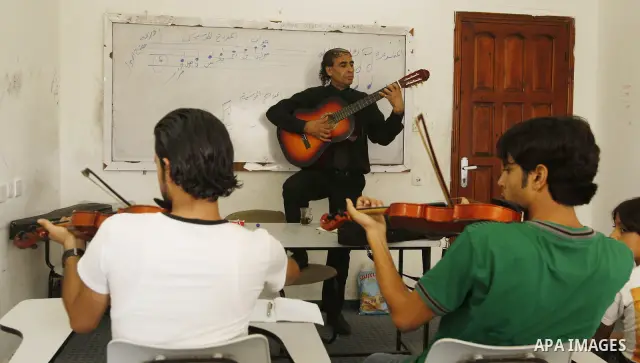 A Palestinian Music teacher during teaching students on on musical instruments at the Gaza College in the Department of Music in Gaza city on July 30, 2011. Photo by Mahmud Nassar