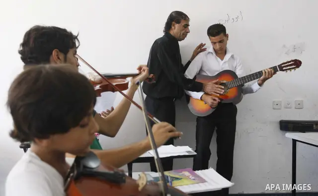 A Palestinian boy plays on musical instruments at the Gaza College in the Department of Music in Gaza city on July 30, 2011. Photo by Mahmud Nassar