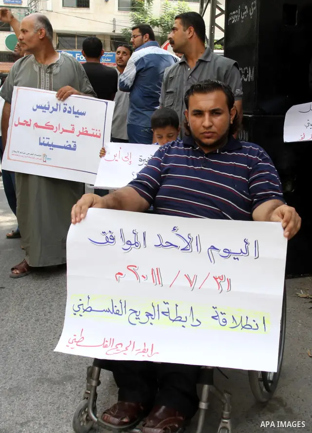 Palestinians wounded, take part in a protest demanding the authority of Ramallah to grant them their rights and entitlements in Gaza city on July 31, 2011. Photo by Mohammed Asad