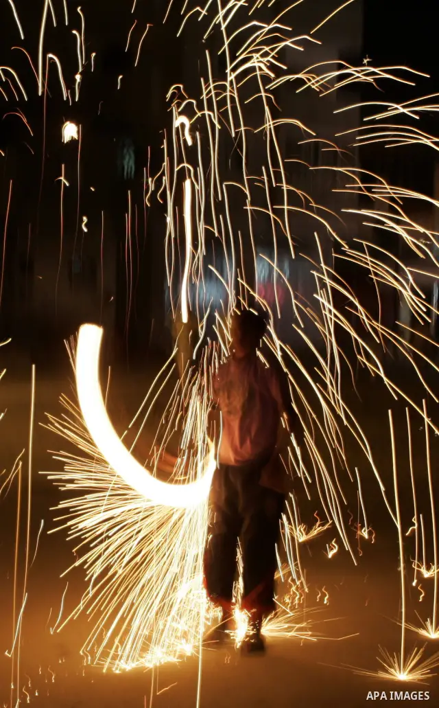 A Palestinian boy plays with fire crackers celebrating ahead of the Muslim holy month of Ramadan, in Rafah, southern Gaza Strip on July 30, 2011, where today is the complement of the month of Sha'ban, and tomorrow is the...
