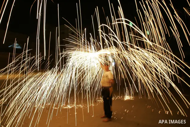 A Palestinian boy plays with fire crackers celebrating ahead of the Muslim holy month of Ramadan, in Rafah, southern Gaza Strip on July 30, 2011, where today is the complement of the month of Sha'ban, and tomorrow is the...