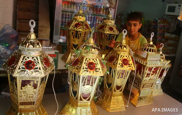 A Palestinian boy displays lanterns outside his shop ahead of the Muslim holy fasting month of Ramadan at Al-Zawiya market in Gaza City on July 31, 2011. Photo by Ashraf Amra