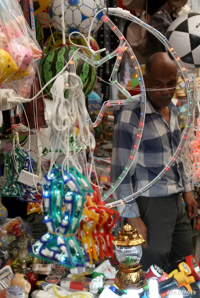Palestinians walk through a market decorated for the holy fasting month of Ramadan, in the West Bank city of Nablus, Sunday, July 31, 2011. Muslims throughout the world will celebrate the holy fasting month of Ramadan, t...