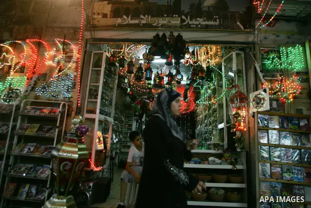 A Palestinian woman walks under decorations ahead of the Muslim holy month of Ramadan in Jerusalem's Old City July 31, 2011. Muslims around the world abstain from eating, drinking and sexual relations from sunrise to sun...
