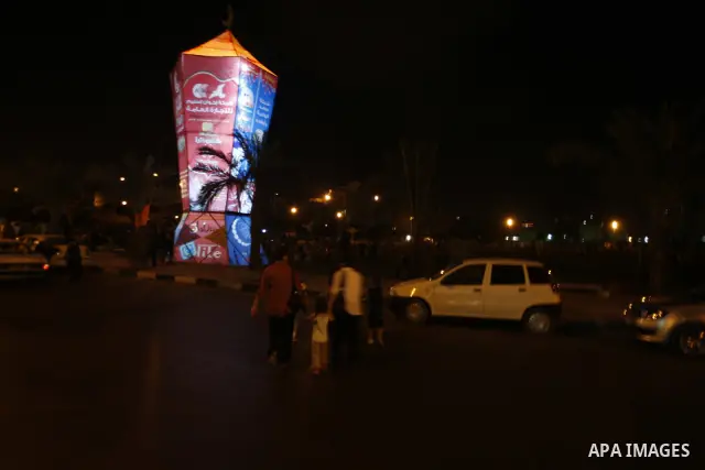 Palestinians sit and walk around a giant lantern set to mark the Muslim holy fasting month of Ramadan on July 31, 2011 in Gaza City. Photo by Mahmud Nassar