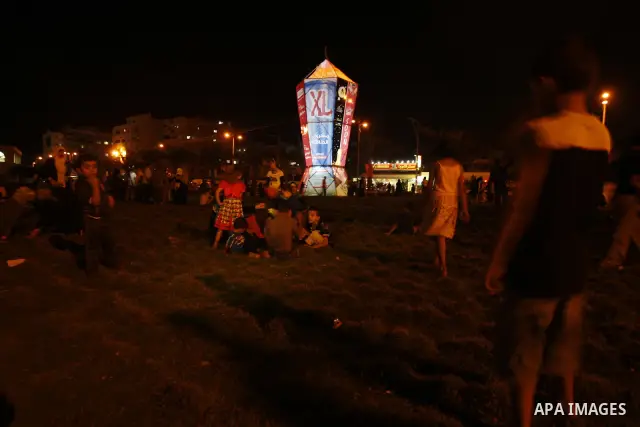 Palestinians sit and walk around a giant lantern set to mark the Muslim holy fasting month of Ramadan on July 31, 2011 in Gaza City. Photo by Mahmud Nassar
