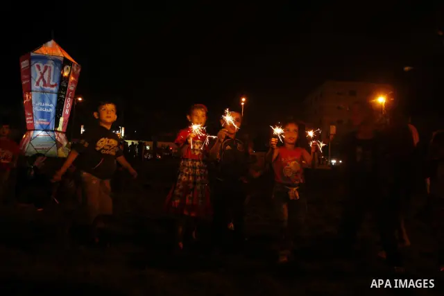 Palestinians sit and walk around a giant lantern set to mark the Muslim holy fasting month of Ramadan on July 31, 2011 in Gaza City. Photo by Mahmud Nassar