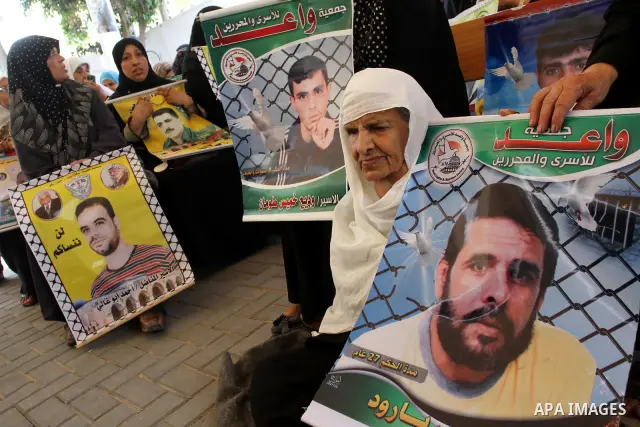Palestinians women hold pictures of their prisoned relatives in Israeli jails as they gather in a weekly activity calling for their liberty at the Red Cross headquarters in Gaza City on Aug.1, 2011. About 7000 prisoners...