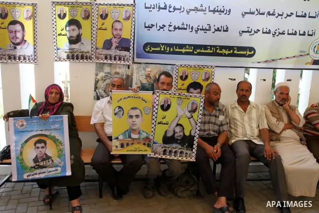 Palestinians women hold pictures of their prisoned relatives in Israeli jails as they gather in a weekly activity calling for their liberty at the Red Cross headquarters in Gaza City on Aug.1, 2011. About 7000 prisoners...