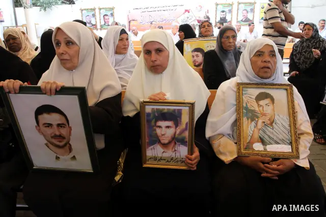 Palestinians women hold pictures of their prisoned relatives in Israeli jails as they gather in a weekly activity calling for their liberty at the Red Cross headquarters in Gaza City on Aug.1, 2011. About 7000 prisoners...