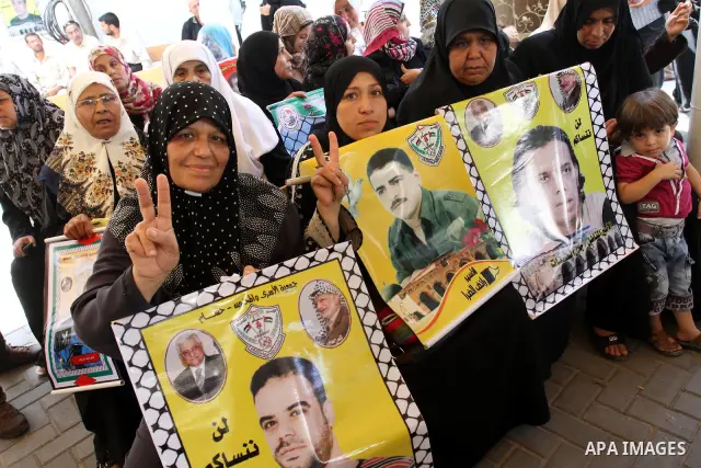 Palestinians women hold pictures of their prisoned relatives in Israeli jails as they gather in a weekly activity calling for their liberty at the Red Cross headquarters in Gaza City on Aug.1, 2011. About 7000 prisoners...