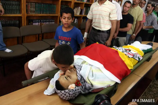 Palestinian relaives of Ali Khalifa 25, kiss during his funeral at the West bank refugee camp of Qalandia, near Ramallah, 01 August 2011, on the first day of the Muslim holy month of Ramadan. Reports state that Israeli s...